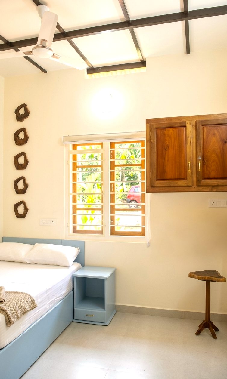 3 BHK bedroom with a soft blue bed and a garden window