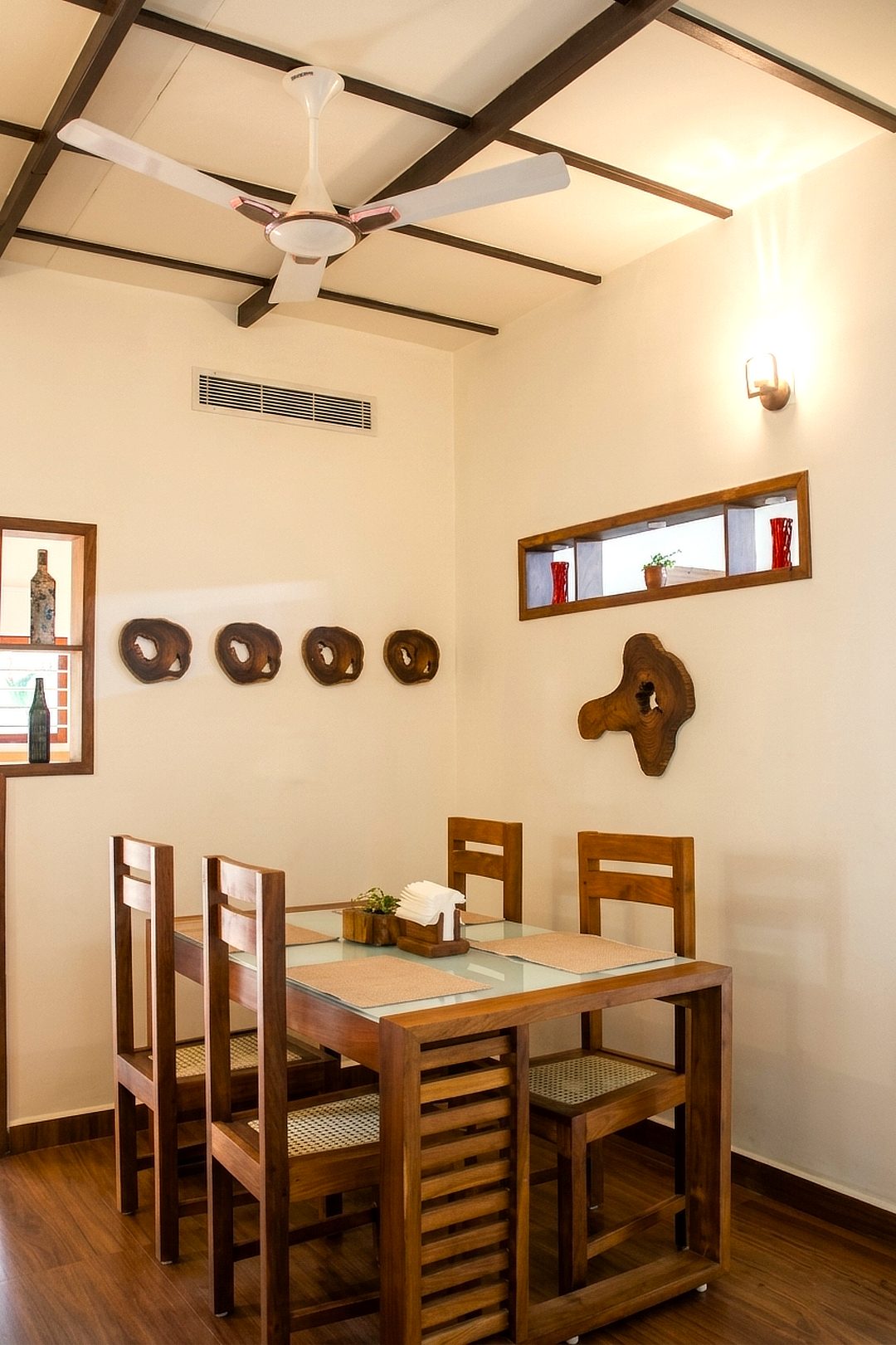 Wooden dining table and chairs under a timber-beam ceiling