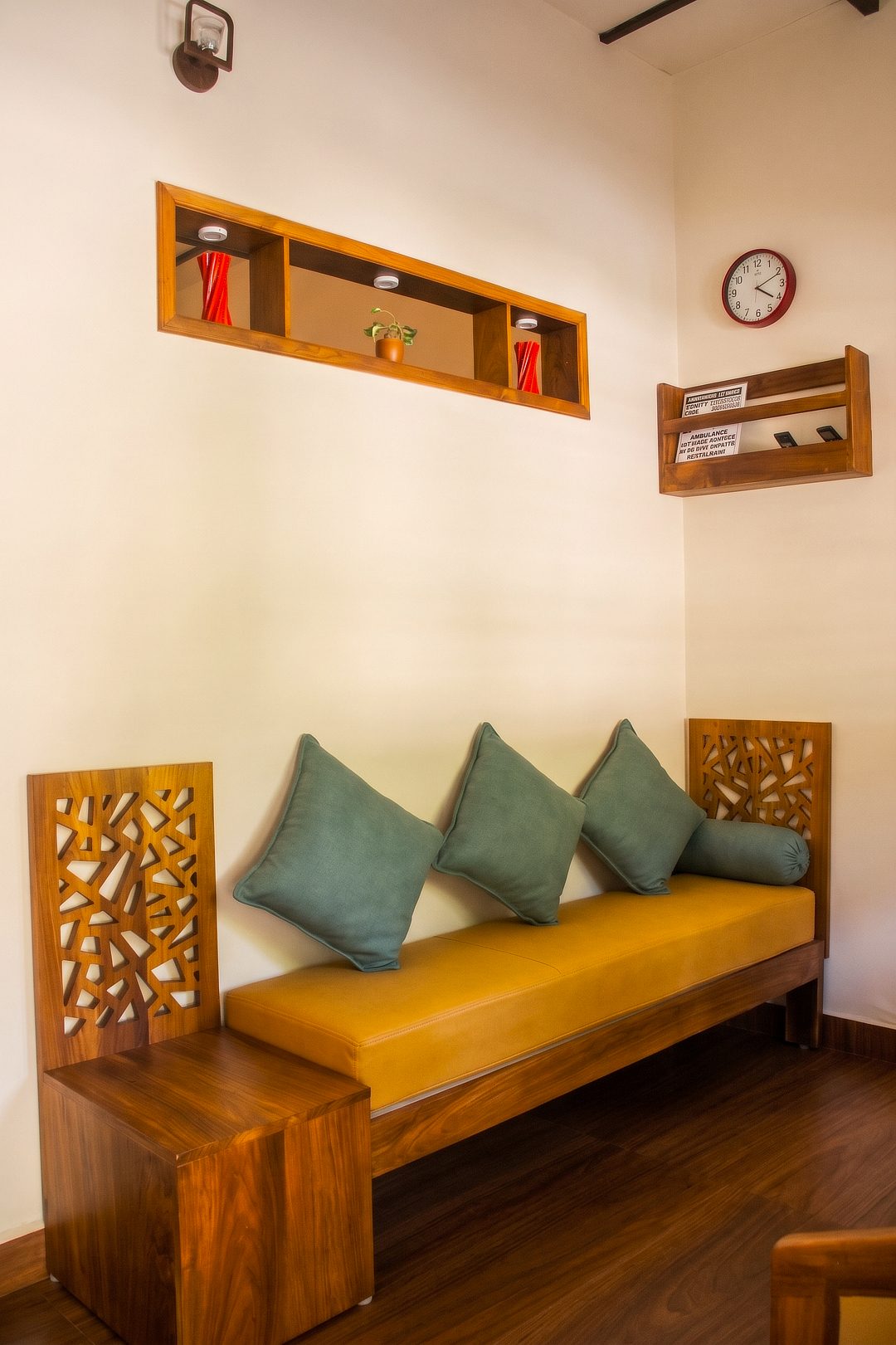 3 BHK living room with a carved wooden sofa and teal cushions